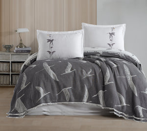 Gray floral-patterned comforter and pillows on a bed in a bedroom