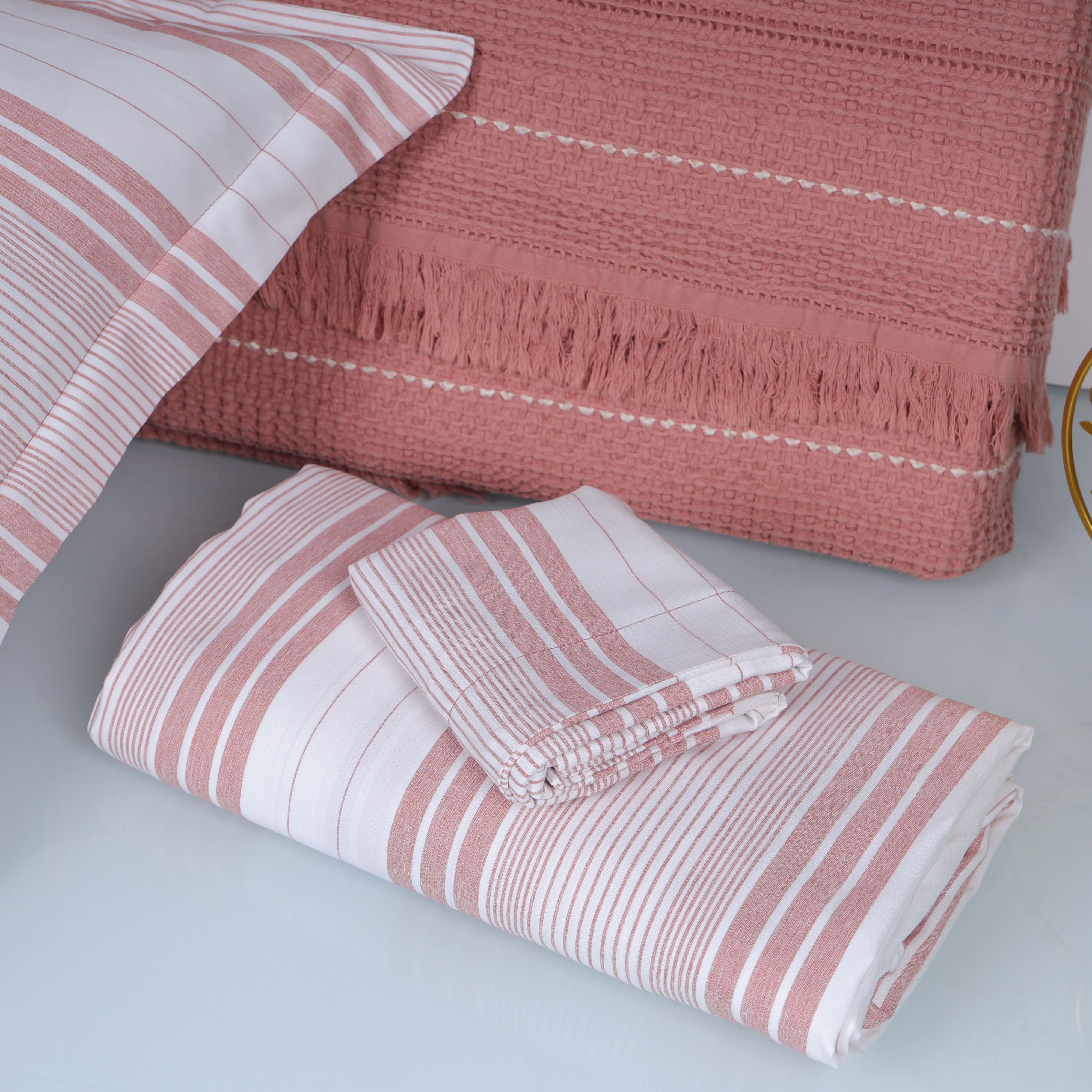 Pink and white striped bedsheet set with a textured pink cotton throw