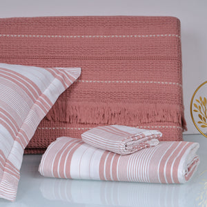 Pink and white striped bedsheey on a bed with a matching headboard