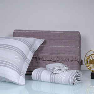 Gray striped bedding set with a pillow and folded blanket 