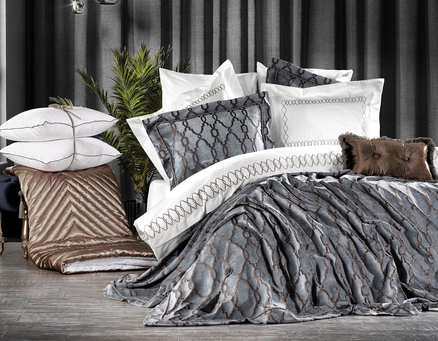 Luxury bedding set with patterned comforter and pillows on a bed.